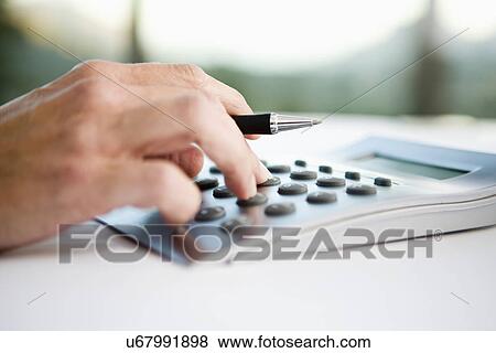 Businessman using calculator, close-up View Large Photo Image Stock Photo - Businessman using calculator, close-up. Fotosearch