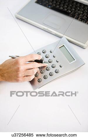 Businessman using calculator, elevated view View Large Photo Image Stock Photography - Businessman using calculator, elevated view. Fotosearch