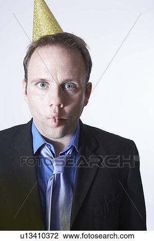 Businessman wearing party hat, making a face View Large Photo Image Stock Image - Businessman wearing party hat, making a face. Fotosearch