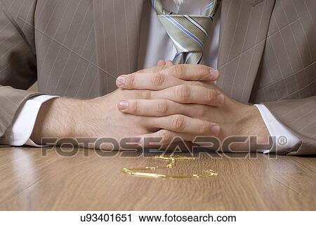 Businessman with his hand clasped sitting in front of desk with question mark drawn on it View Large Photo Image Stock Image - Businessman with his hand clasped sitting in front of desk with question mark drawn on it. Fotosearch
