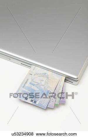 Stock Photo - Canadian banknotes in laptop. Fotosearch