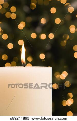 Candle with Christmas tree in background View Large Photo Image Stock Photography - Candle with Christmas tree in background. Fotosearch