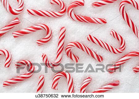 Stock Image - Candy canes in snow. Fotosearch