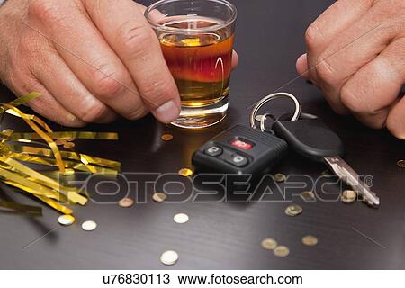Car keys lying next to man holding glass of whiskey View Large Photo Image Stock Image - Car keys lying next to man holding glass of whiskey. Fotosearch