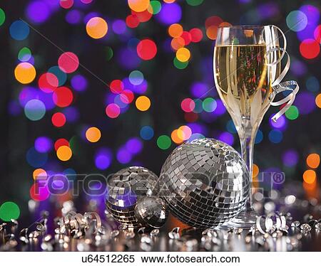 Stock Photography - Champagne glass and disco balls on colorful background. Fotosearch