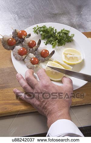 Stock Photo - Chef preparing seafood, close-up of hands. Fotosearch