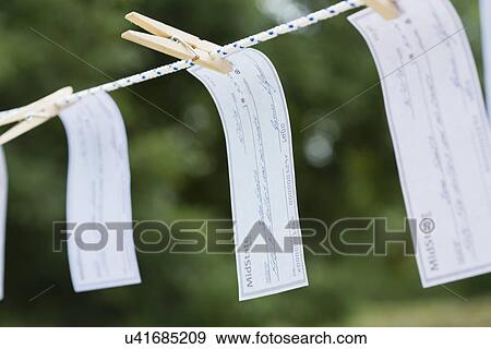 Cheques hanging on clothesline View Large Photo Image Stock Photo - Cheques hanging on clothesline. Fotosearch