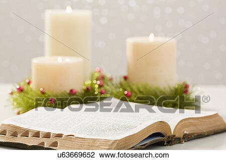 Stock Image - Christmas candles and open bible. Fotosearch