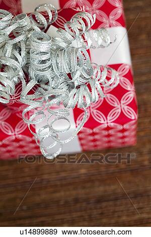 Christmas gift with silver ribbon, directly above View Large Photo Image Stock Photo - Christmas gift with silver ribbon, directly above. Fotosearch