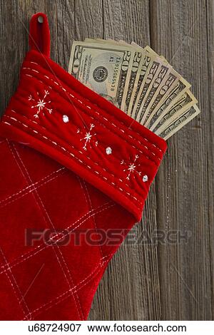 Stock Photo - Close up of Christmas stocking with paper currency sticking out of it. Fotosearch