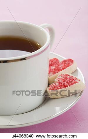 Stock Image - Close-up of coffee cup with heartshaped cookies. Fotosearch