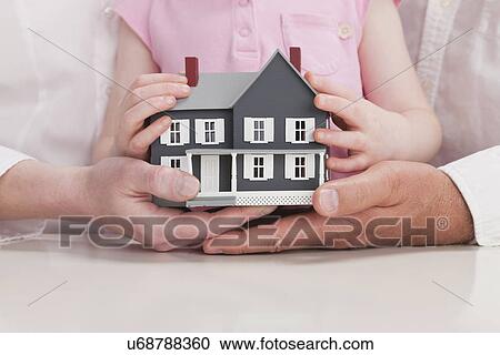 Close up of family hands holding model house View Large Photo Image Stock Image - Close up of family hands holding model house. Fotosearch