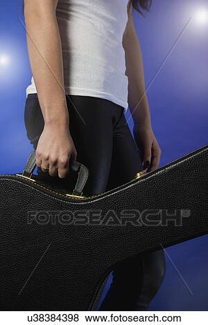 Close up of female musician holding guitar case View Large Photo Image Stock Photo - Close up of female musician holding guitar case. Fotosearch