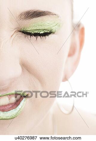 Close up of girl (14-15) with green make up making a face View Large Photo Image Stock Photo - Close up of girl (14-15) with green make up making a face. Fotosearch