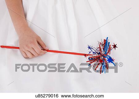 Close-up of girl's (8-9) hand holding Fourth of July wand View Large Photo Image Stock Photograph - Close-up of girl's (8-9) hand holding Fourth of July wand. Fotosearch