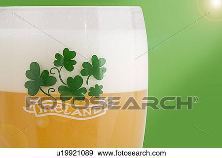 Close up of glass of beer and shamrock View Large Photo Image Stock Photo - Close up of glass of beer and shamrock. Fotosearch