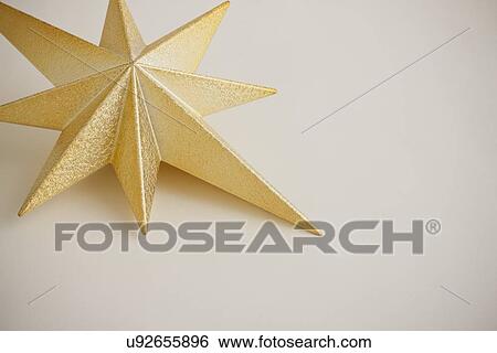 Stock Photograph - Close up of gold Christmas tree toper. Fotosearch