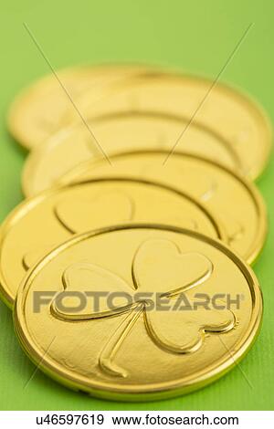 Stock Photo - Close up of gold coins with shamrock pattern. Fotosearch