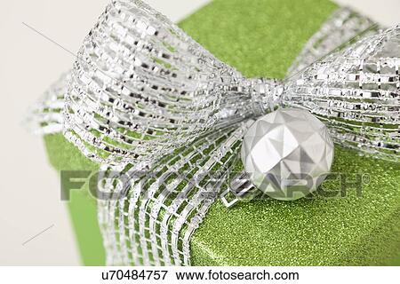 Close-up of green gift with christmas bulb View Large Photo Image Stock Photo - Close-up of green gift with christmas bulb. Fotosearch