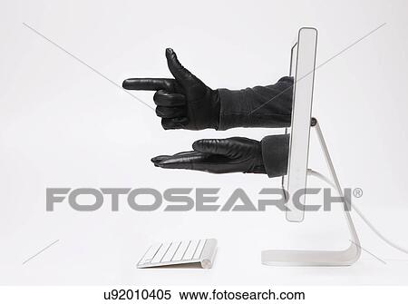 Stock Photography - Close up of hands in black gloves emerging from monitor. Fotosearch