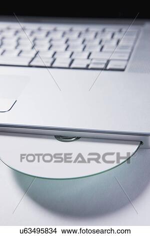 Picture - Close-up of laptop ejecting CD. Fotosearch