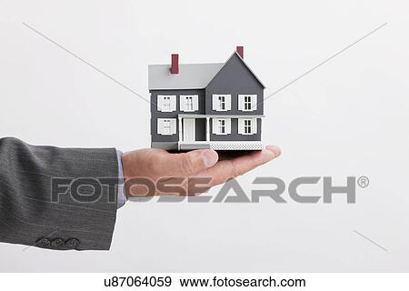 Close up of man's hand holding model house View Large Photo Image Stock Photo - Close up of man's hand holding model house. Fotosearch