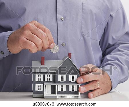 Close up of man's hands throwing coin into model house View Large Photo Image Stock Image - Close up of man's hands throwing coin into model house. Fotosearch