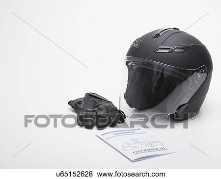 Stock Photo - Close up of motorcycle helmet, leather gloves and safety guideline book, studios shot. Fotosearch
