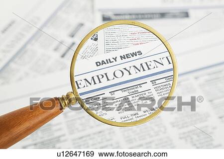 Stock Photo - Close-up of newspaper page seen through magnifying glass. Fotosearch