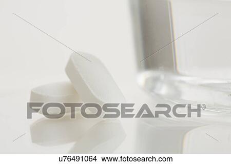Picture - Close-up of painkiller and glass of water. Fotosearch