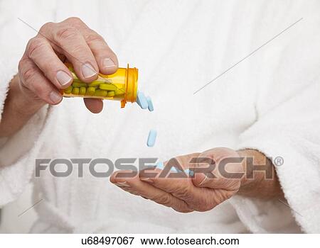 Stock Photo - Close up of senior man's hands pouring out pills. Fotosearch