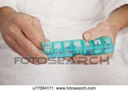 Close up of senior's hands taking pill from pill organizer View Large Photo Image Stock Image - Close up of senior's hands taking pill from pill organizer. Fotosearch