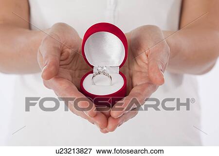 Close-up of woman's hands holding diamond ring in box View Large Photo Image Stock Photo - Close-up of woman's hands holding diamond ring in box. Fotosearch