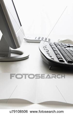 Stock Photograph - Computer and piece of paper on office desk. Fotosearch