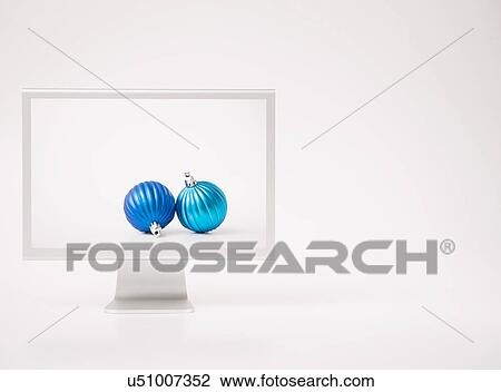 Stock Image - Computer monitor with Christmas baubles. Fotosearch