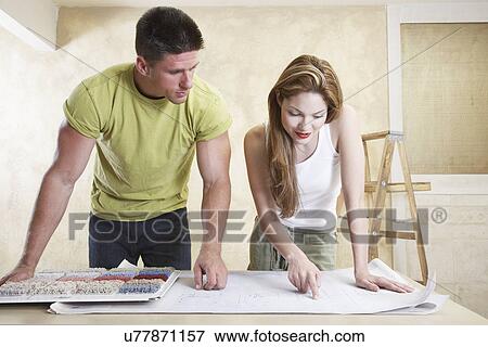 Stock Photo - Couple looking at carpet samples and blueprint. Fotosearch