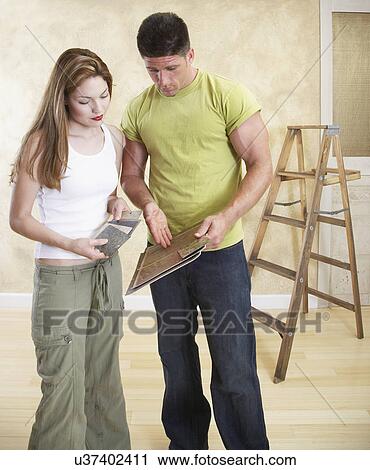 Stock Image - Couple looking at flooring and countertop samples. Fotosearch