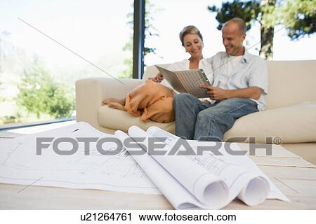 Couple sitting on sofa with blueprints in foreground View Large Photo Image Stock Image - Couple sitting on sofa with blueprints in foreground. Fotosearch
