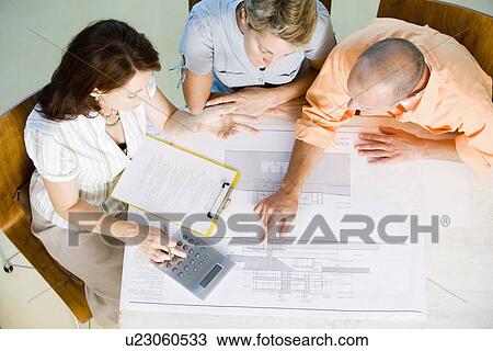 Couple with female architect looking at blueprint, high angle view View Large Photo Image Stock Image - Couple with female architect looking at blueprint, high angle view. Fotosearch