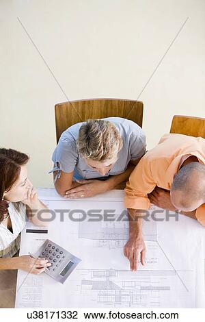 Couple with female architect looking at blueprint, high angle view View Large Photo Image Stock Image - Couple with female architect looking at blueprint, high angle view. Fotosearch
