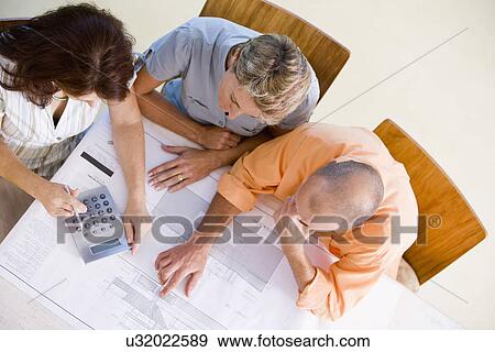 Couple with female architect looking at blueprint, high angle view View Large Photo Image Stock Photo - Couple with female architect looking at blueprint, high angle view. Fotosearch