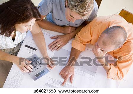 Couple with female architect looking at blueprint, high angle view View Large Photo Image Stock Photo - Couple with female architect looking at blueprint, high angle view. Fotosearch