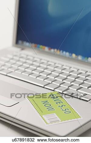 Stock Image - Coupon and laptop, close-up. Fotosearch