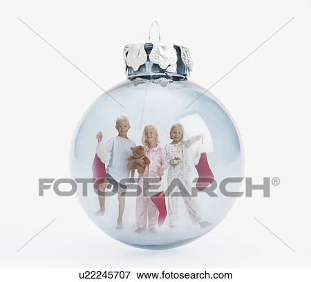 Stock Photo - Digital composite of smiling children (4-5, 8-9) with christmas stockings inside christmas bulb. Fotosearch