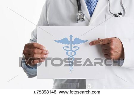 Doctor holding paper with graphic of Caduceus symbol View Large Photo Image Stock Photograph - Doctor holding paper with graphic of Caduceus symbol. Fotosearch