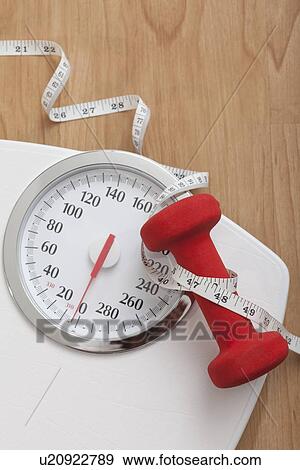 Dumbbell and tape measure on bathroom scales View Large Photo Image Stock Photo - Dumbbell and tape measure on bathroom scales. Fotosearch