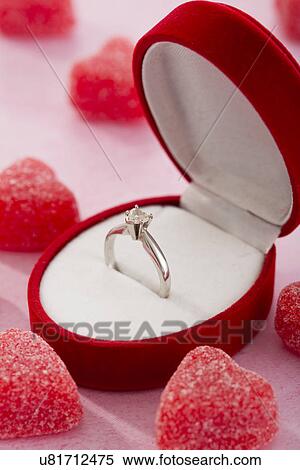 Stock Photography - Engagement ring in heartshaped box and sweets. Fotosearch