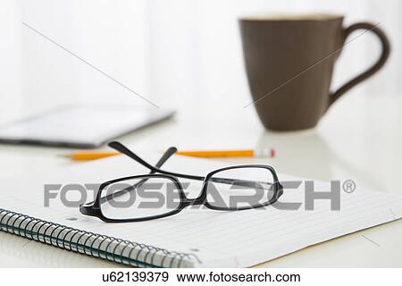 Stock Photo - Eyeglasses on spiral notebook. Fotosearch