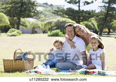 Stock Image - Family having picnic in park. Fotosearch