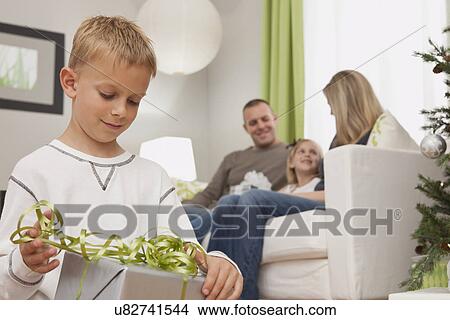 Picture - Family with boy and girl (6-7, 8-9) celebrating christmas. Fotosearch